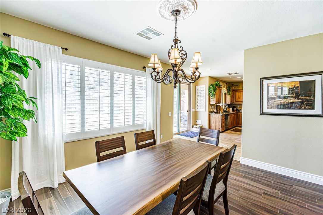 75 Tall Ruff Drive Las Vegas, NV 89148 - Photo 11 of 64 Rich wood plank flooring and a classic chandelier define this welcoming dining space.