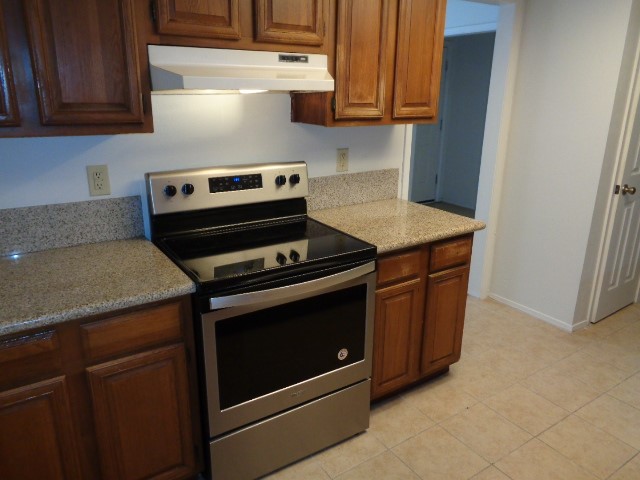9530 Magnolia Ridge Drive Houston, TX 77070 - Photo 20 of 20 a kitchen with wooden cabinets and a stove top oven