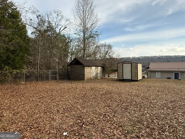 a view of a dry yard with wooden fence