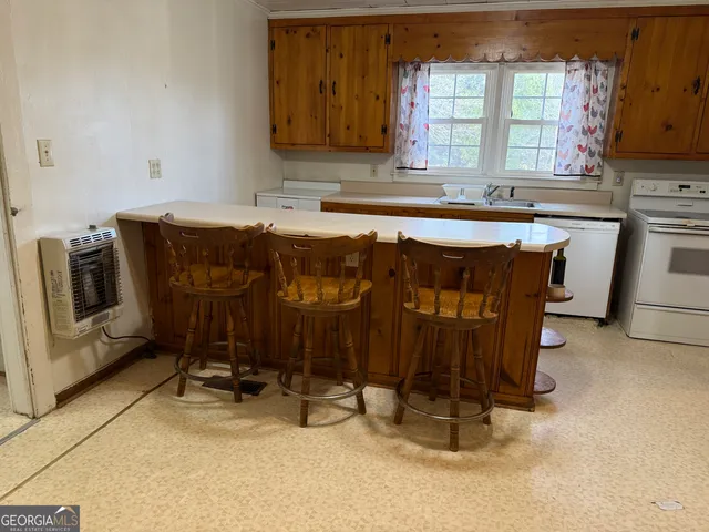 a kitchen with a sink chairs and appliances