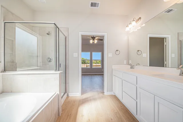 a en suite bathroom with a tub shower and mirror