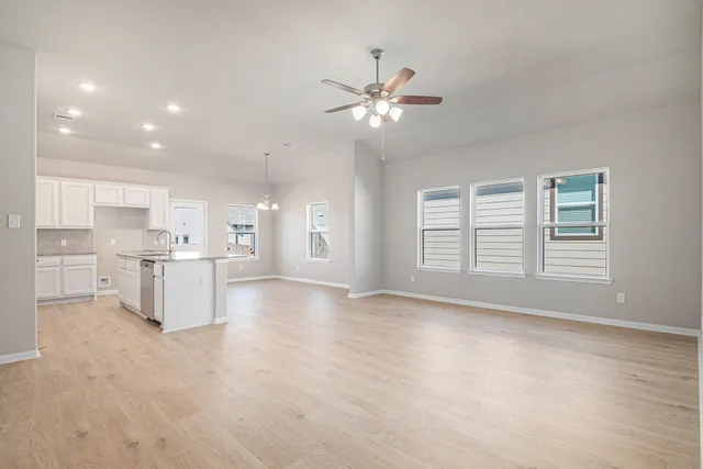 a view of an empty room with kitchen appliances and a window