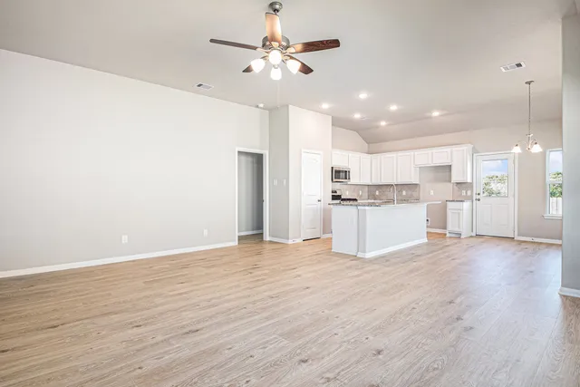 a view of kitchen with granite countertop cabinets and refrigerator