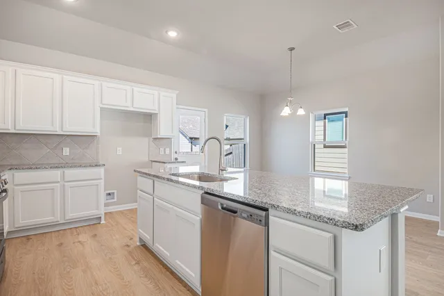 a kitchen with granite countertop white cabinets and white appliances