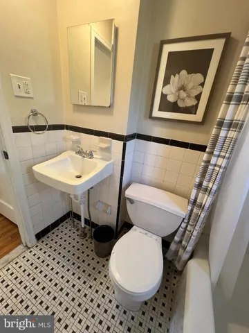 a bathroom with a toilet a sink and mirror