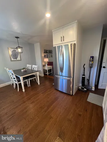 a view of a room with wooden floor shoes and a refrigerator