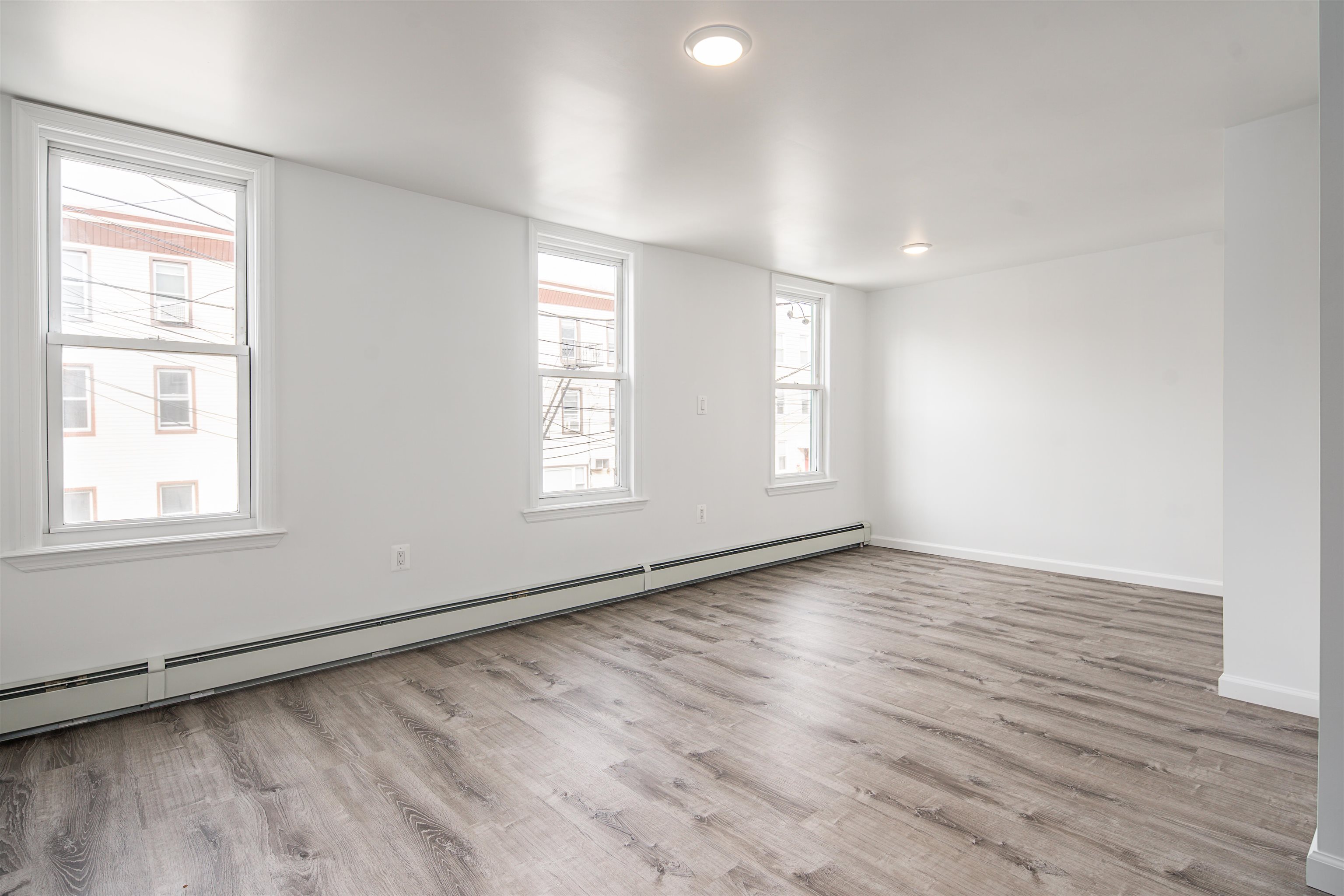 74 Colgate Street, Unit 2 Jersey City, NJ 07302 - Photo 6 of 10 an empty room with wooden floor and windows