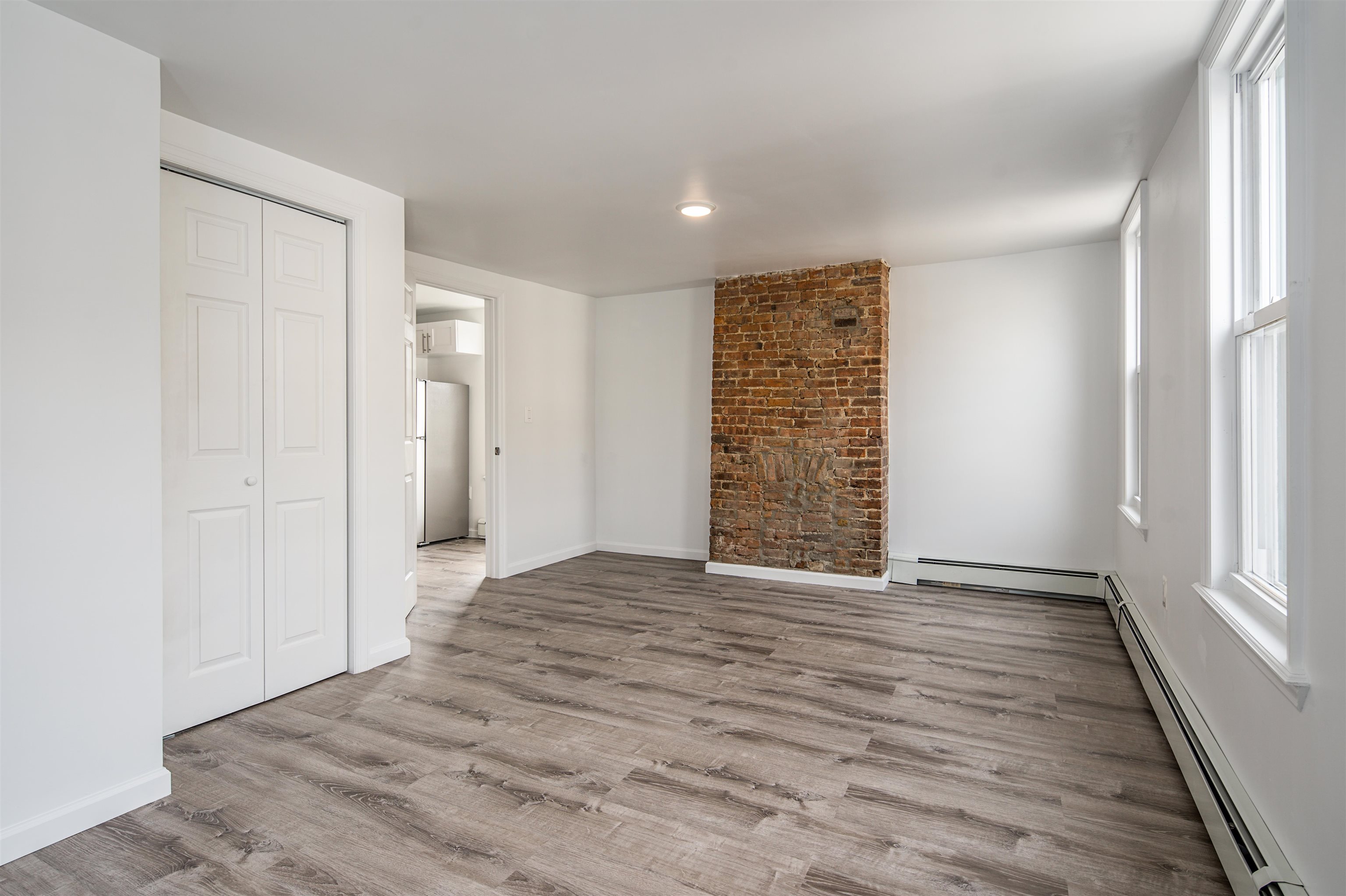 74 Colgate Street, Unit 2 Jersey City, NJ 07302 - Photo 8 of 10 a view of an empty room with wooden floor and a window