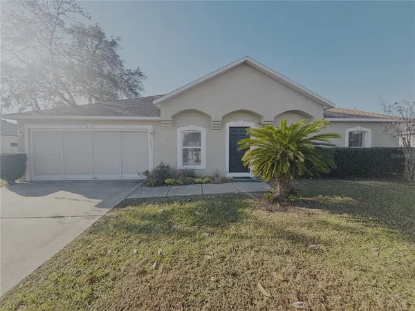 a front view of house with yard and trees around