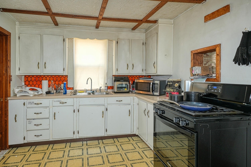 7 Prospect Street Woburn, MA 01801 - Photo 24 of 40 a kitchen with stainless steel appliances a stove and white cabinets