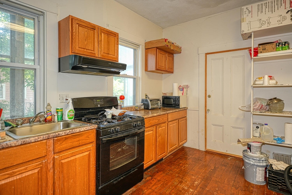 7 Prospect Street Woburn, MA 01801 - Photo 8 of 40 a kitchen with stainless steel appliances granite countertop a stove a sink and a microwave