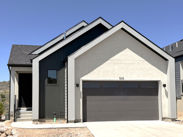 529 East Rimrock Lane Heber City, UT 84032 - Photo 1 of 20 Contemporary exterior featuring a two-tone facade, attached two-car garage, covered entry, gabled rooflines, and exterior wall sconces