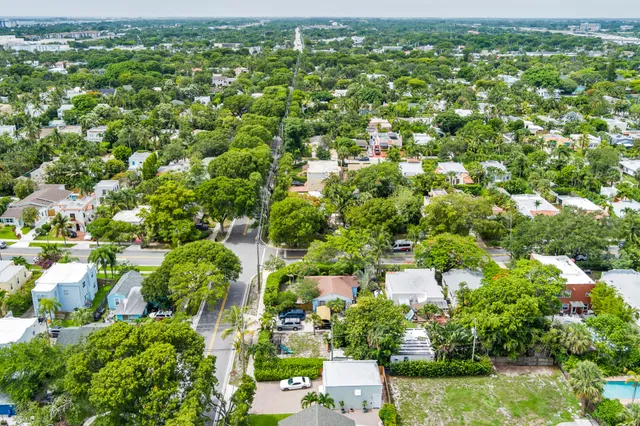 an aerial view of residential houses with outdoor space and trees