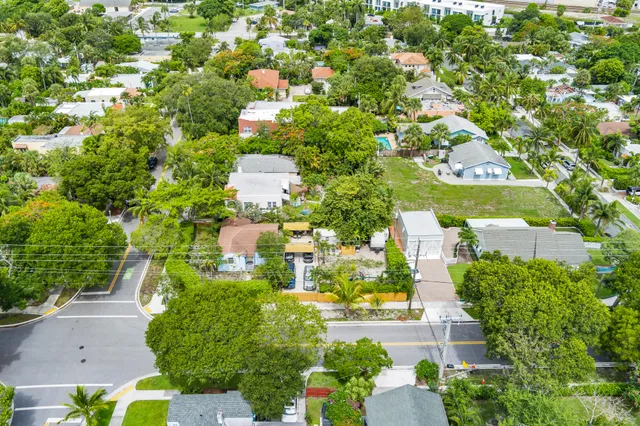 an aerial view of residential houses with outdoor space and trees all around