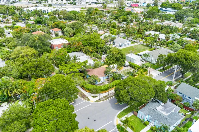 an aerial view of a house with a yard and large trees