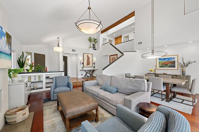 a kitchen with granite countertop a stove top oven a sink dishwasher a dining table and chairs with wooden floor