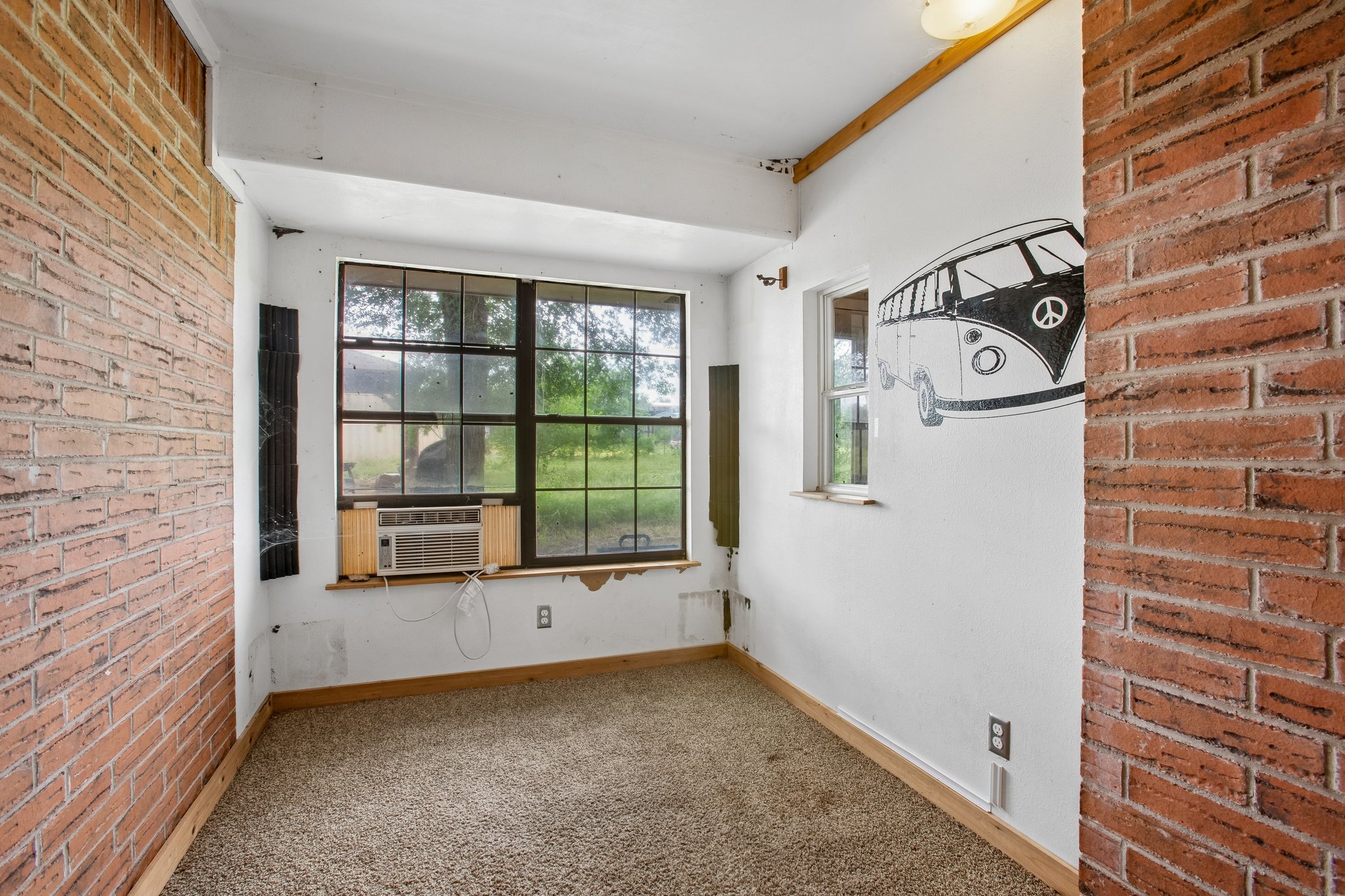 406 Monkey Road Elgin, TX 78621 - Photo 19 of 39 Interior space featuring brick wall accents, carpet flooring, and multiple windows