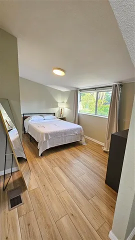 a bedroom with two beds and wooden floor