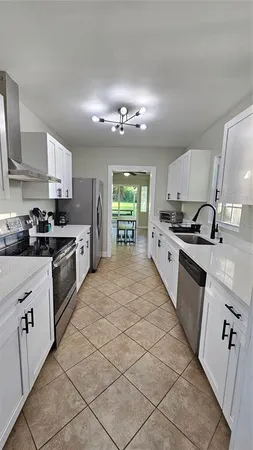 a large kitchen with stainless steel appliances granite countertop a stove a sink dishwasher and a refrigerator