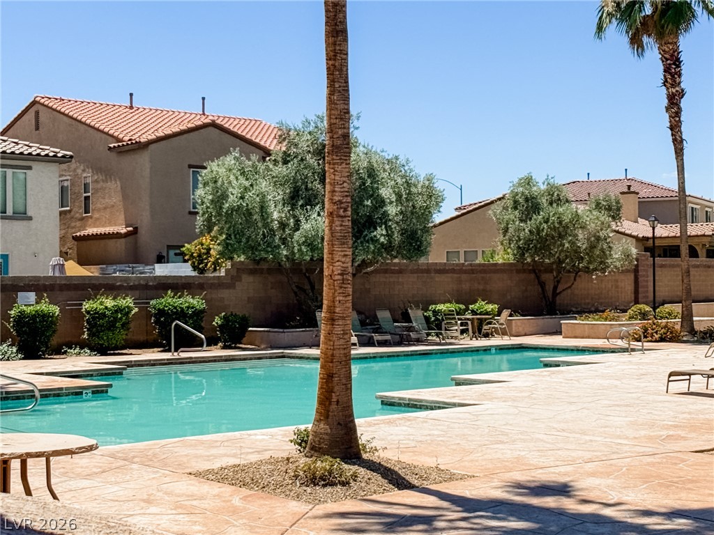 7701 West Robindale Road, Unit 110 Las Vegas, NV 89113 - Photo 19 of 21 A refreshing outdoor pool awaits, flanked by ample lounging space and verdant landscaping.