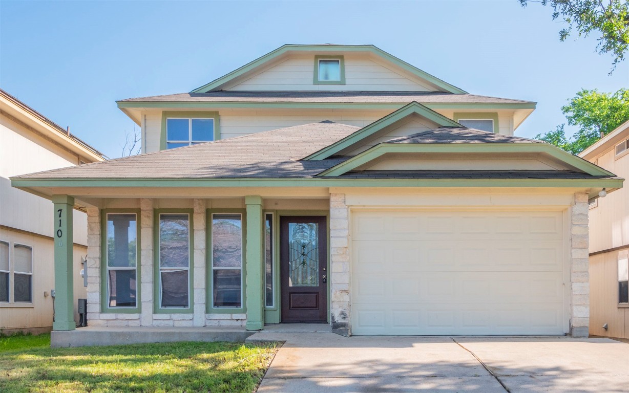 a view of a white house with large windows and a small yard