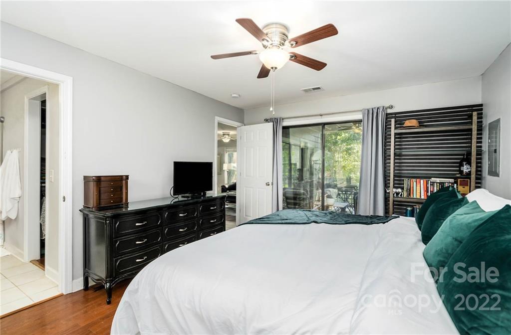 308 Queens Road, Unit 29 Charlotte, NC 28204 - Photo 11 of 20 a bedroom with a large bed and a flat tv screen on dresser
