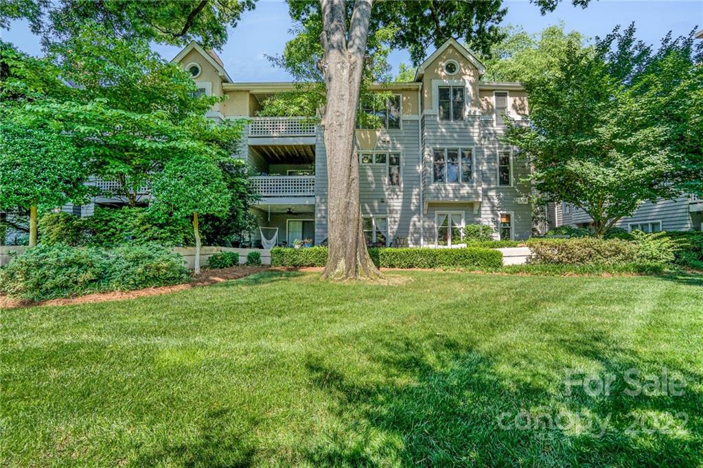 308 Queens Road, Unit 29 Charlotte, NC 28204 - Photo 18 of 20 a view of a big yard in front of a brick house with large windows