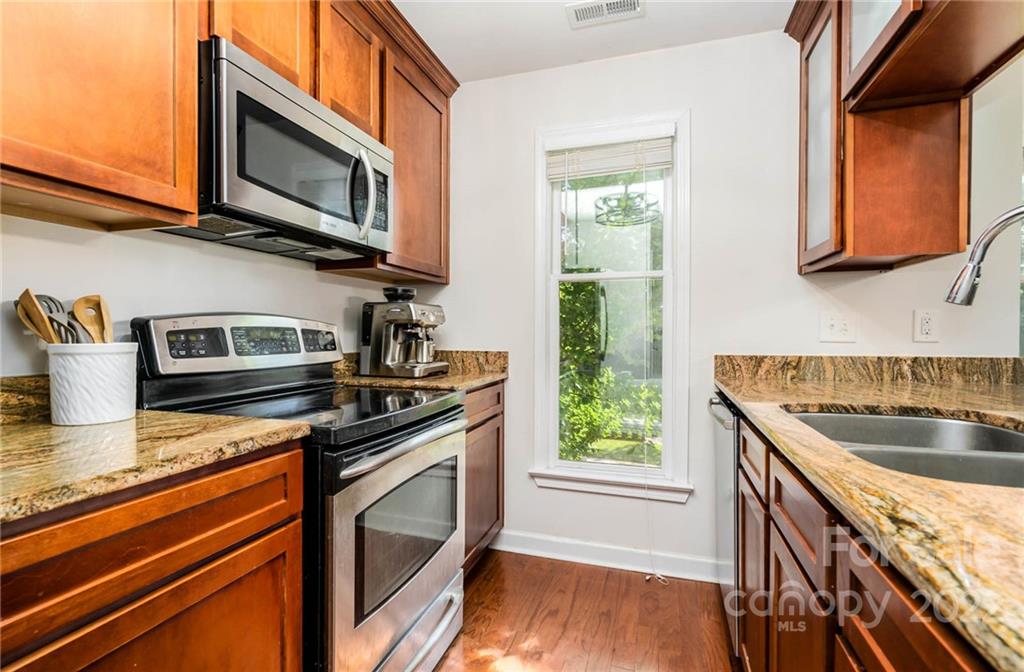 308 Queens Road, Unit 29 Charlotte, NC 28204 - Photo 4 of 20 a kitchen with stainless steel appliances granite countertop a stove a sink and a microwave