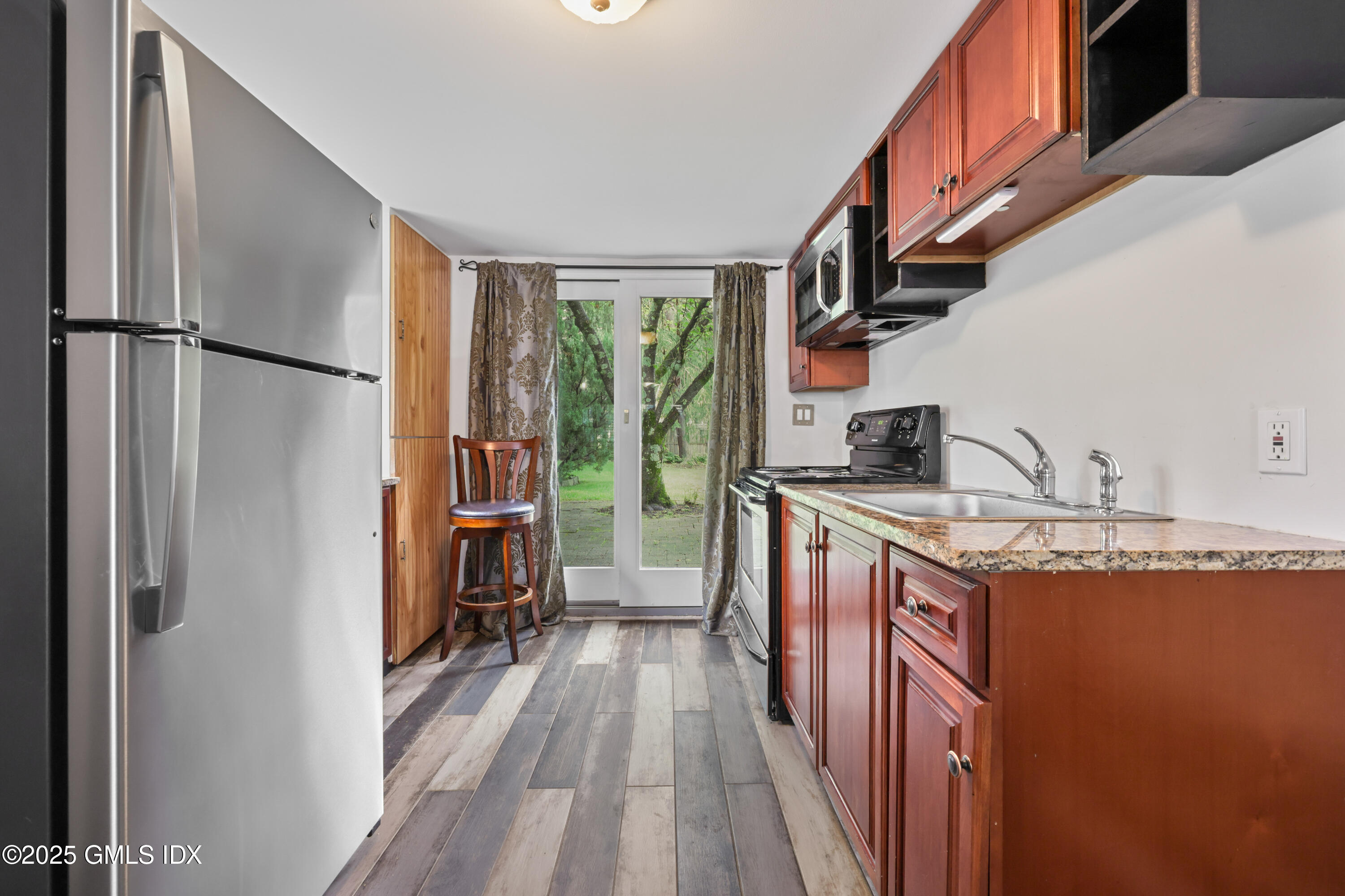 3 Janet Court, Unit 2 Riverside, CT 06878 - Photo 9 of 22 a kitchen with stainless steel appliances granite countertop lots of counter top space and wooden floor