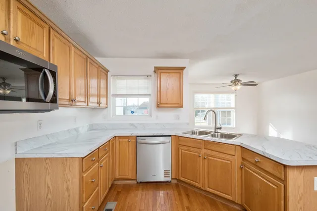 a kitchen with stainless steel appliances granite countertop a sink and a white cabinets