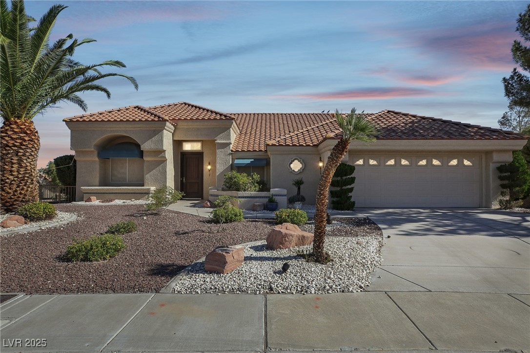 Mediterranean / spanish-style home featuring stucco siding, concrete driveway, an attached garage, and a tile roof