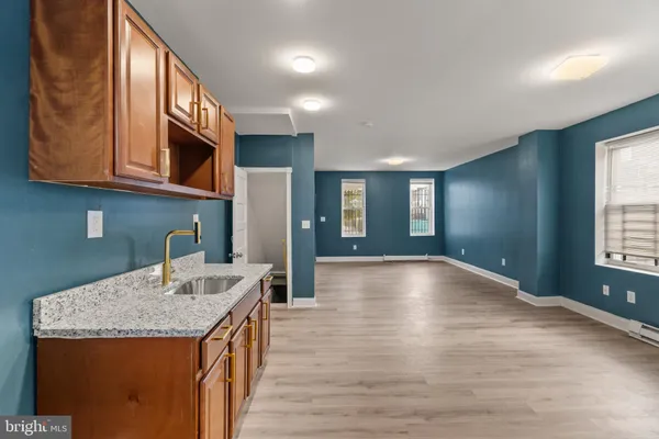 a kitchen with stainless steel appliances granite countertop a sink and cabinets with wooden floor