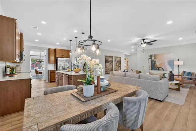 a view of a dining room and livingroom with furniture wooden floor a chandelier