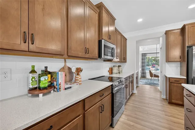 a kitchen with stainless steel appliances a sink dishwasher a microwave oven and a refrigerator with wooden floor