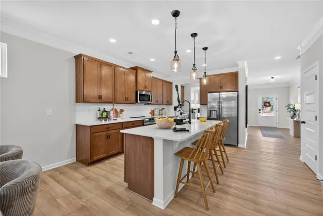 a kitchen with stainless steel appliances kitchen island granite countertop a sink a stove and a refrigerator