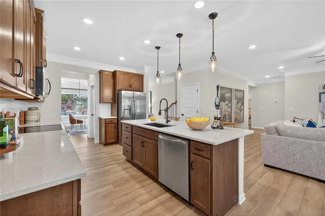 a kitchen with stainless steel appliances granite countertop a sink a stove and a wooden floors