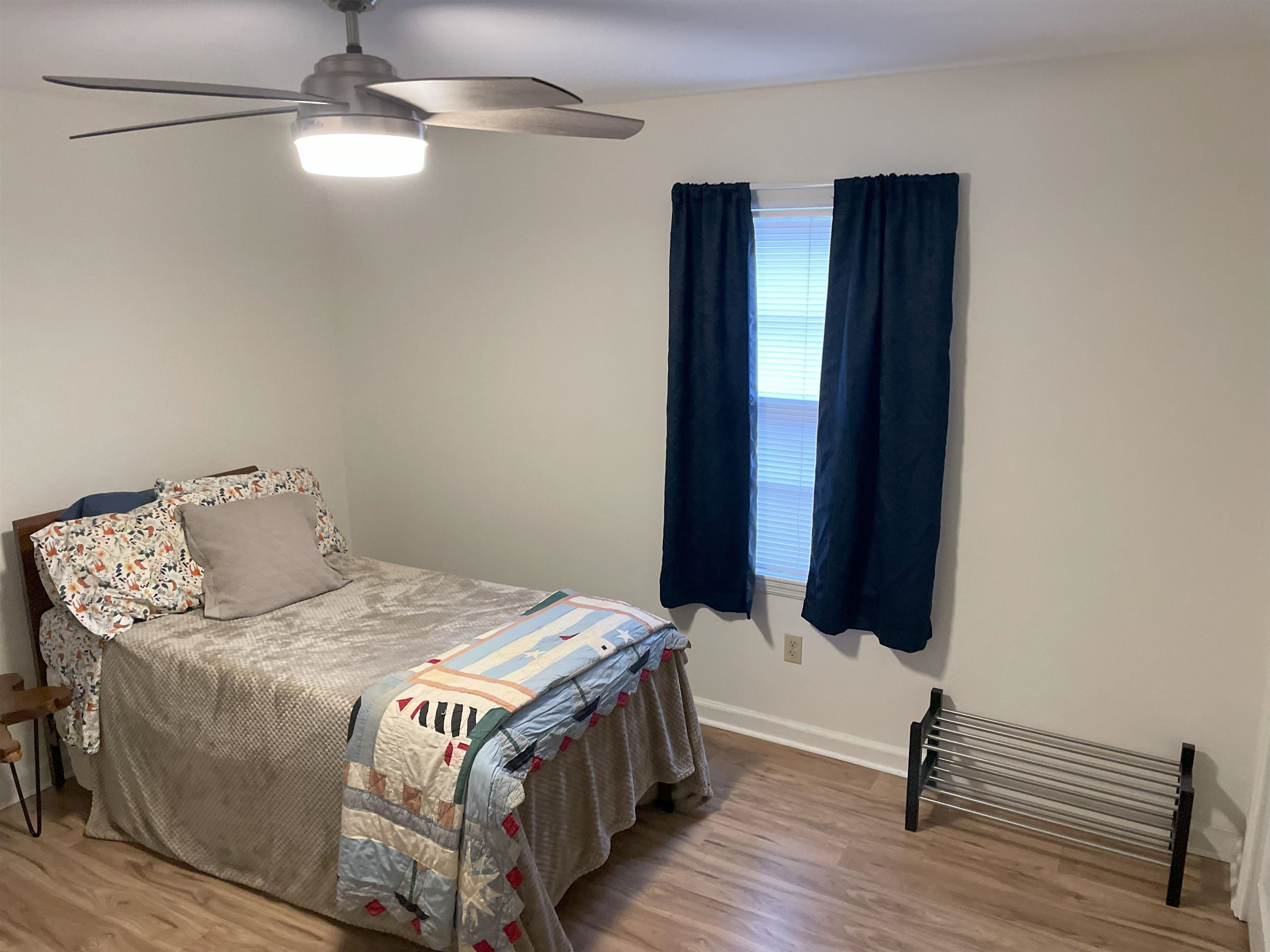 3007 Walnut Grove Road, Unit 1 Memphis, TN 38111 - Photo 11 of 14 a bed sitting in a bedroom next to a window with wooden floor