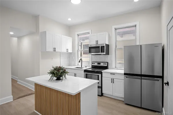 a kitchen with white cabinets and stainless steel appliances