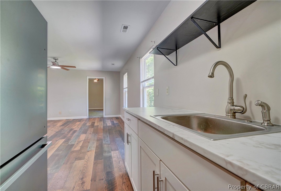 8269 Ark Road Gloucester, VA 23061 - Photo 13 of 33 Kitchen featuring ceiling fan, hardwood / wood-style floors, stainless steel fridge, sink, and white cabinetry