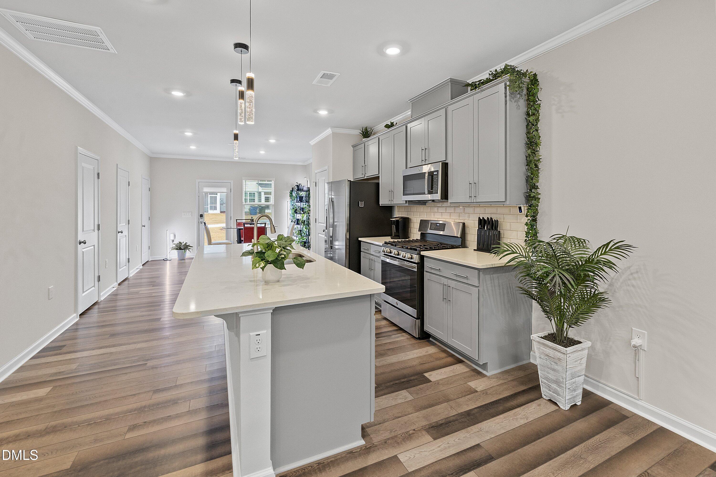 4949 Microcline Trail Raleigh, NC 27610 - Photo 8 of 42 a kitchen with kitchen island white cabinets and stainless steel appliances