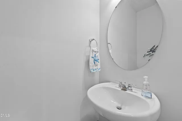 a kitchen with stainless steel appliances a sink a refrigerator a microwave a stove and white cabinets with wooden floor