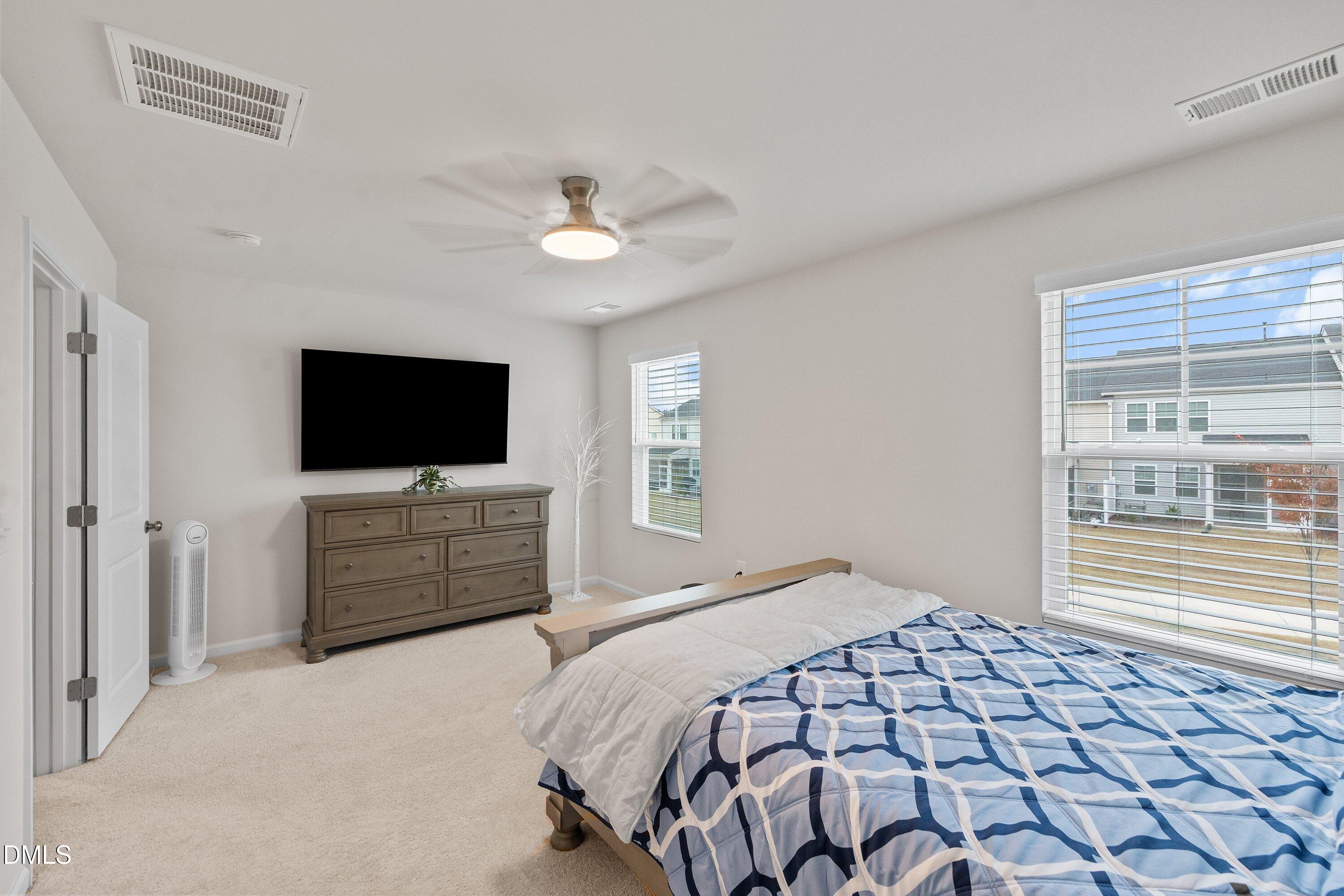 4949 Microcline Trail Raleigh, NC 27610 - Photo 11 of 42 a bedroom with a bed and a flat screen tv