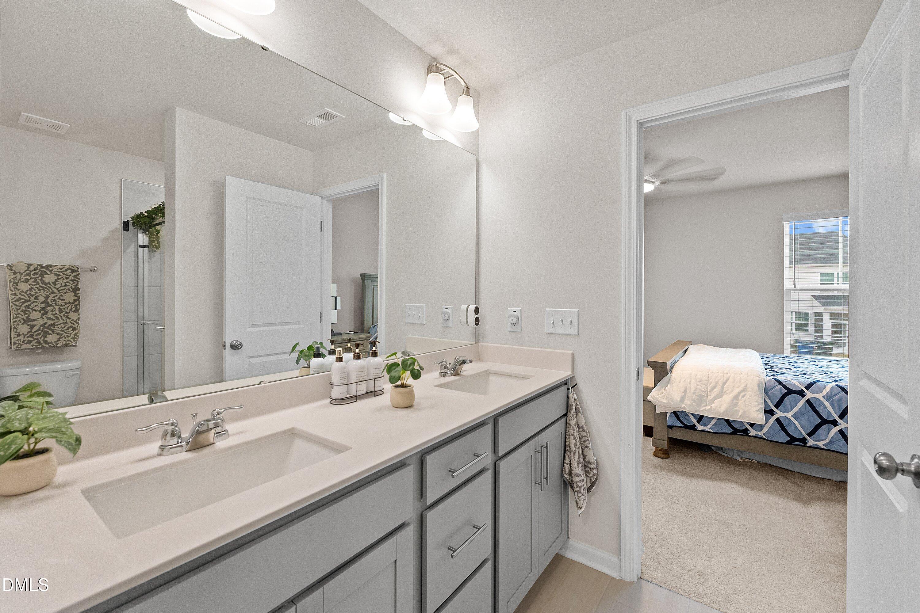 4949 Microcline Trail Raleigh, NC 27610 - Photo 12 of 42 a en suite bathroom with double sink and a mirror