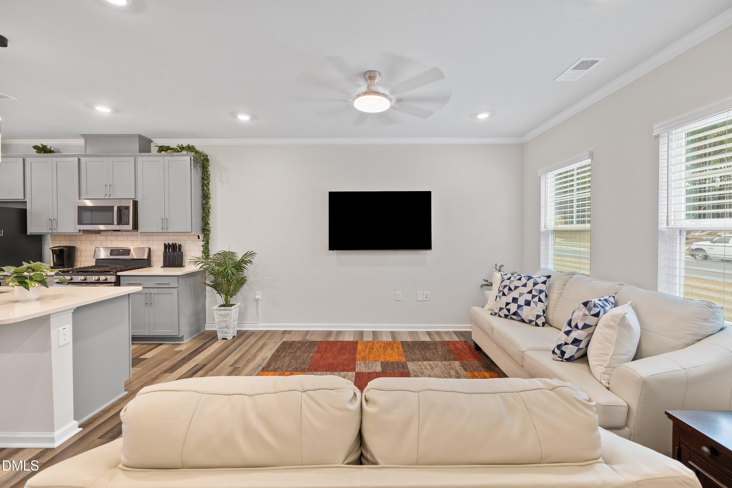 4949 Microcline Trail Raleigh, NC 27610 - Photo 3 of 42 a living room with stainless steel appliances furniture and a flat screen tv