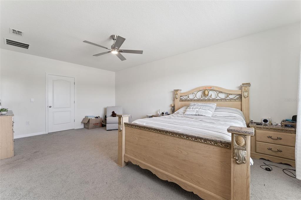 1502 Bitteroot Street Kissimmee, FL 34744 - Photo 11 of 29 a bed room with a bed and a ceiling fan