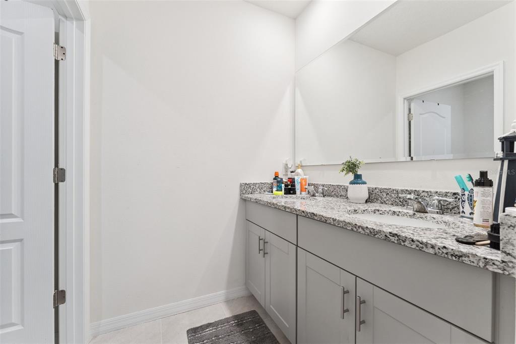 1502 Bitteroot Street Kissimmee, FL 34744 - Photo 17 of 29 a bathroom with a granite countertop sink and a mirror