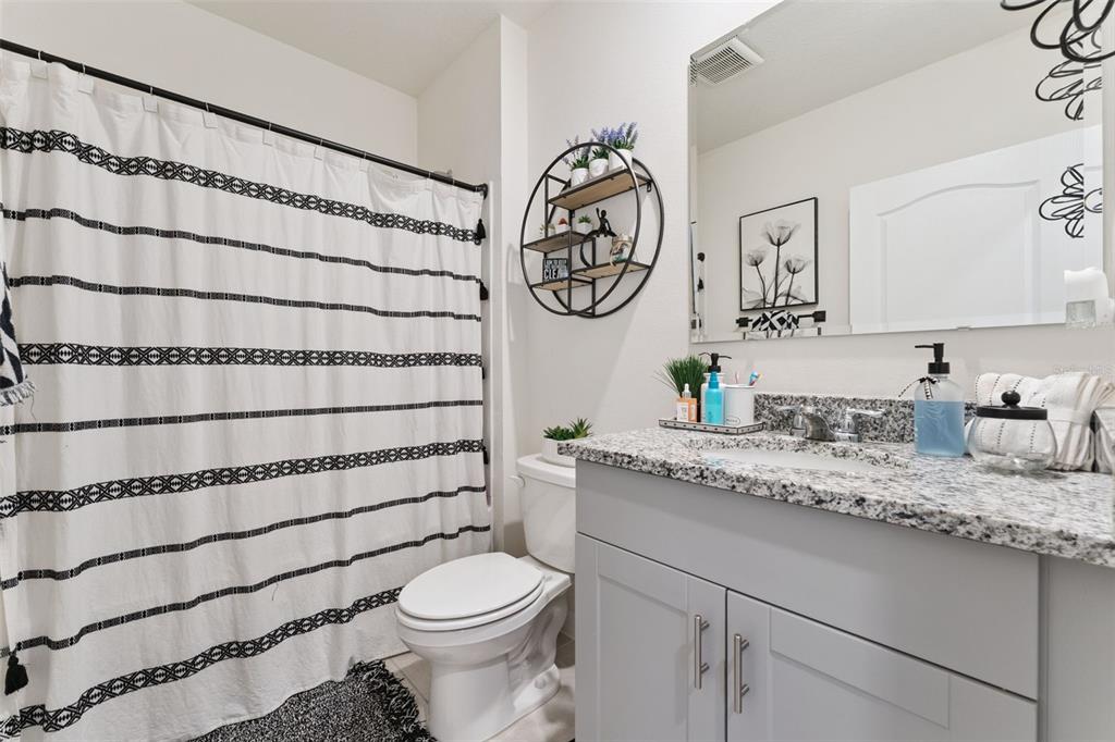 1502 Bitteroot Street Kissimmee, FL 34744 - Photo 18 of 29 a bathroom with a granite countertop sink mirror vanity and toilet