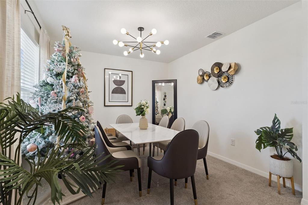 1502 Bitteroot Street Kissimmee, FL 34744 - Photo 3 of 29 a view of a dining room with furniture and chandelier