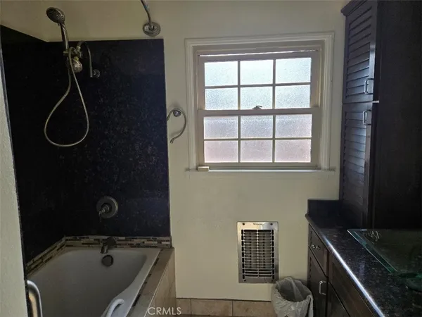 a bathroom with a granite countertop sink a toilet a mirror and vanity