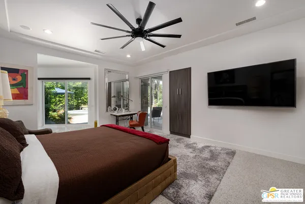a living room with furniture a rug and wall paintings